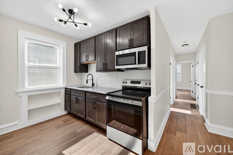 A kitchen with dark brown cabinets and stainless steel appliances.
