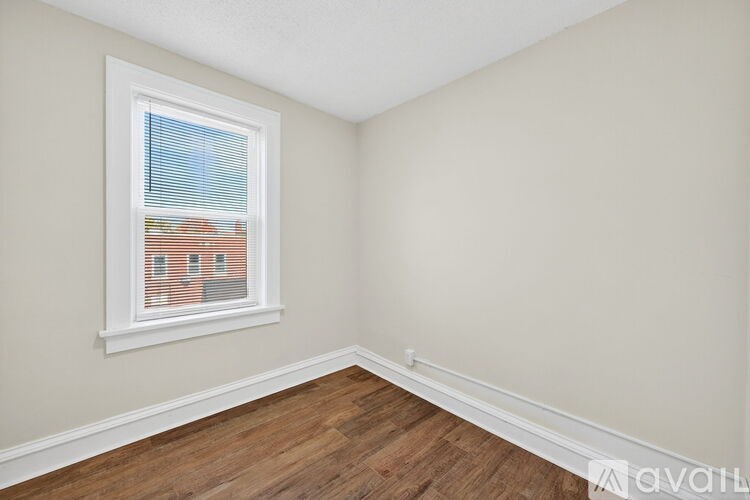 A room with a window and wooden flooring.