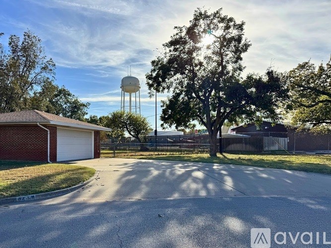 A residential street with a water tower in the background.
