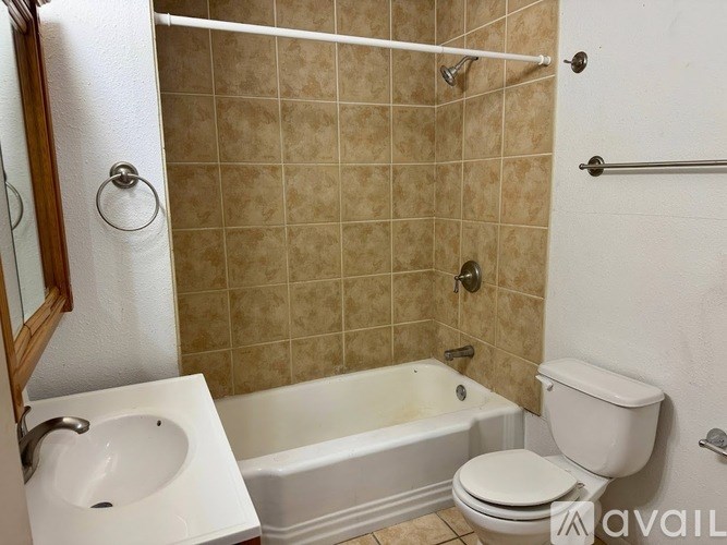 A bathroom with a toilet, sink, and bathtub.