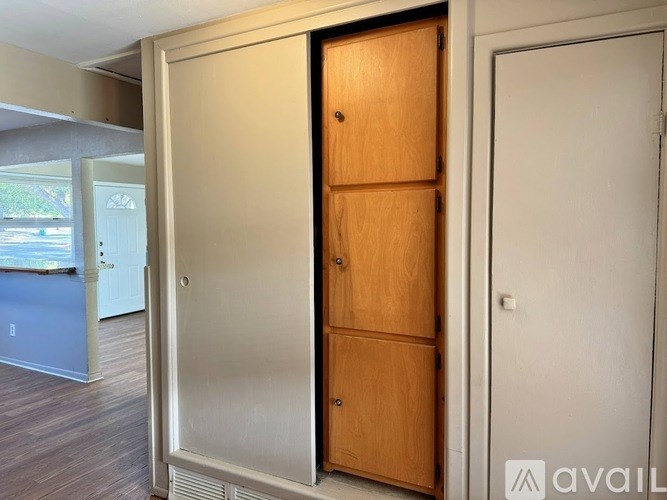 A room with a white door and a wooden cabinet.