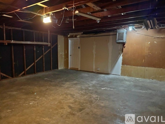 A room with a concrete floor and a door on the right side.