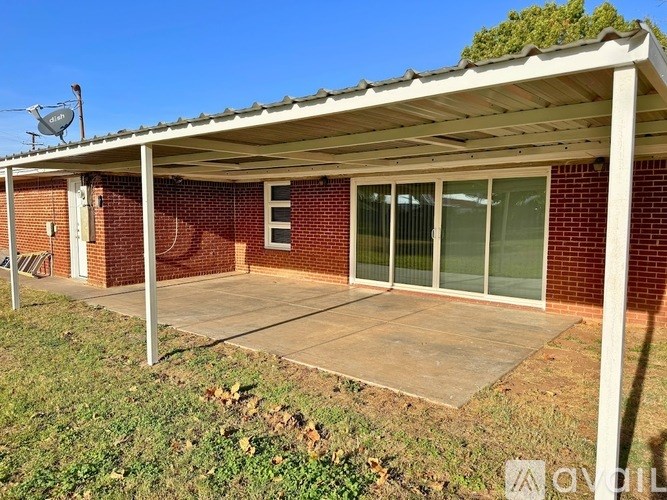A covered patio area with a brick wall and a white roof.