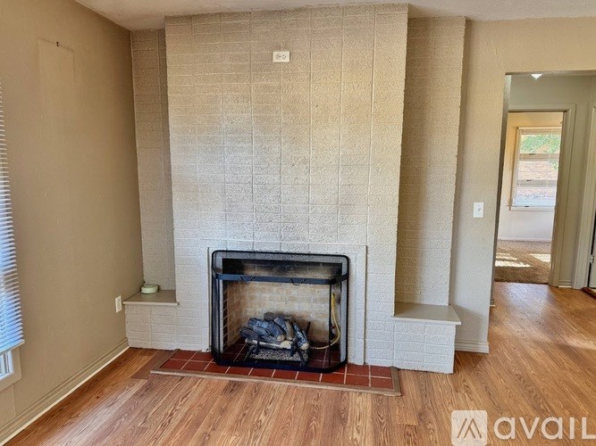 A living room with a fireplace and wood flooring.