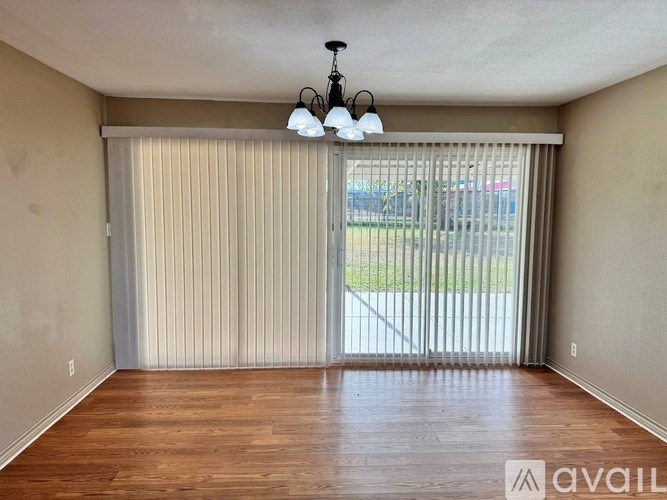 A room with wooden floors and a sliding glass door.