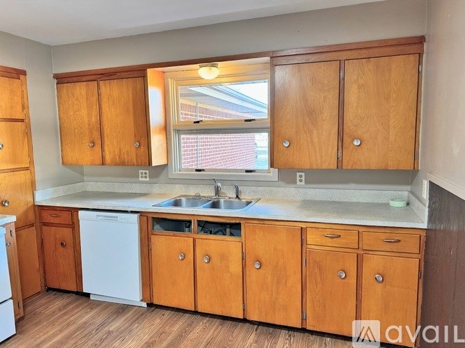 A kitchen with wooden cabinets and a white dishwasher.