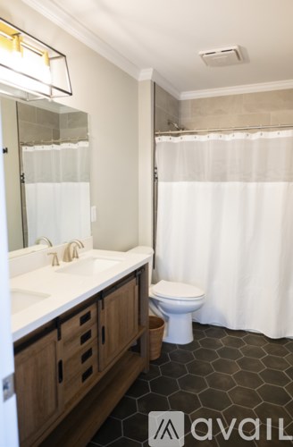 A bathroom with a toilet, sink, and shower.