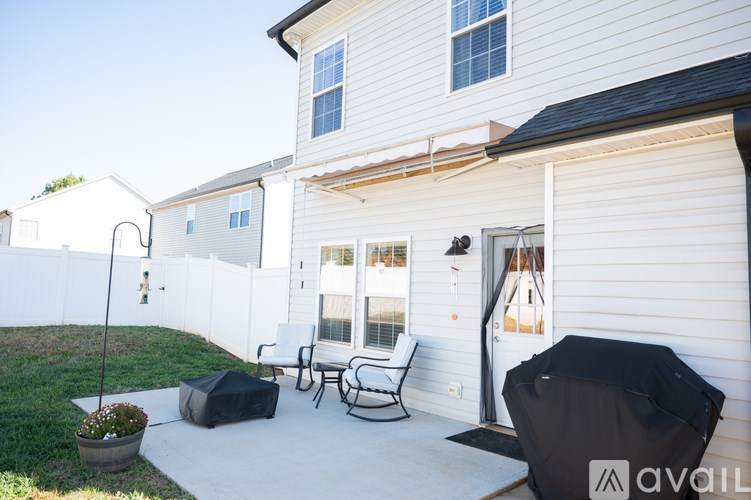 A white house with a patio and outdoor furniture.