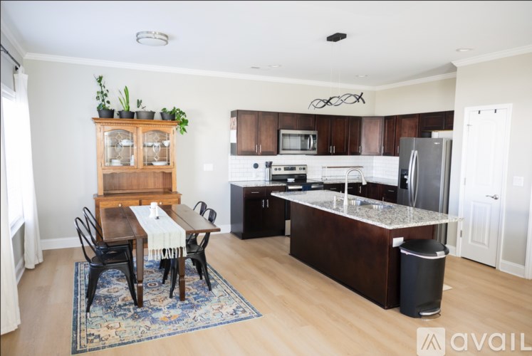 A kitchen with a table and chairs in front of it.