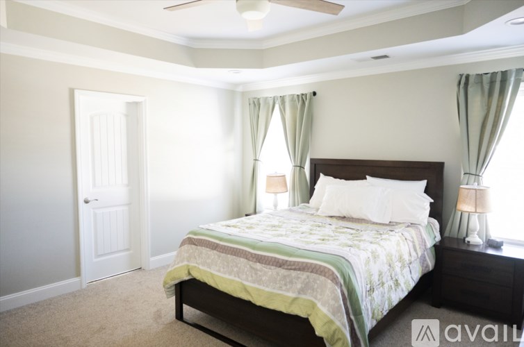 A bedroom with a bed, nightstands, and a ceiling fan.