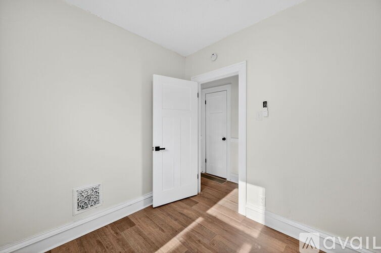 A room with a white door and a white wall.