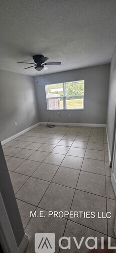A room with a ceiling fan and tiled flooring.