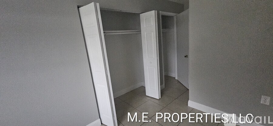 A room with a white door and a grey wall.