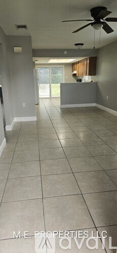 A spacious room with a ceiling fan and tiled flooring.
