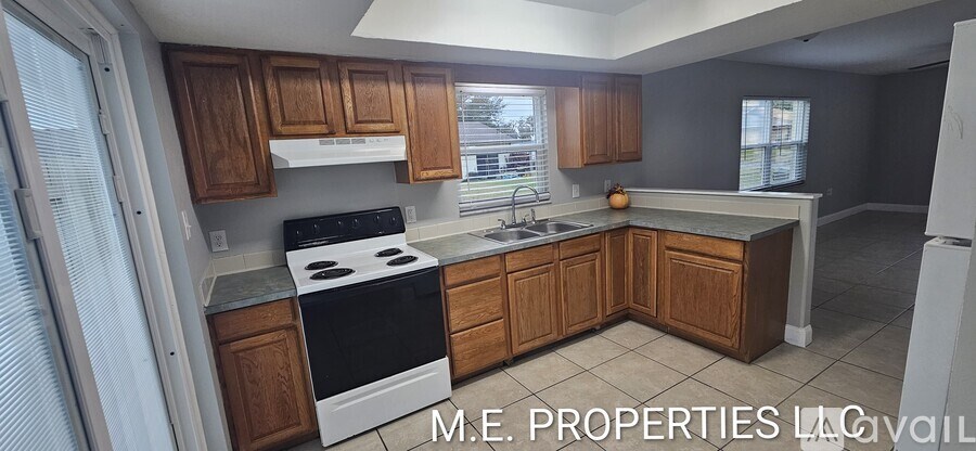 A kitchen with wooden cabinets and a black stove top oven.