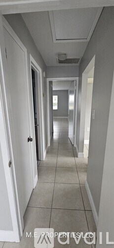A long hallway with white doors on both sides.