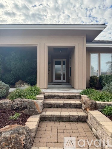A house with a front yard and steps leading to the entrance.