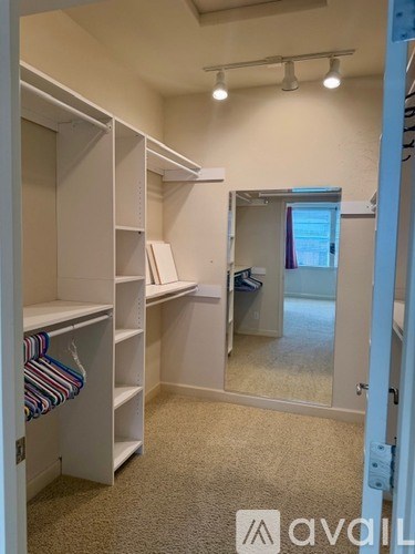 A room with white shelves and a mirror on the wall.