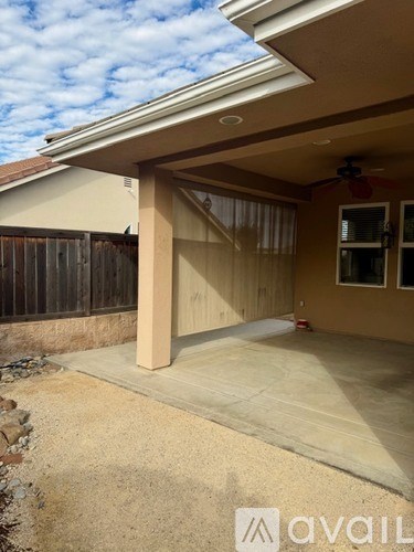 A house with a patio and a ceiling fan.