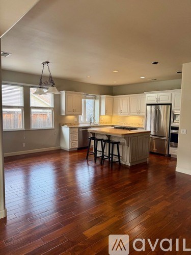 A kitchen with wooden floors and a bar area.
