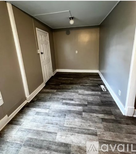 A room with a wooden floor and a white door.
