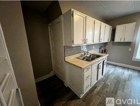 A kitchen with white cabinets and a sink.