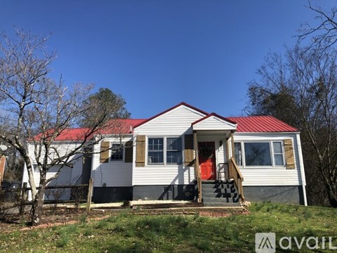 A house with a red roof and a porch with a red door.