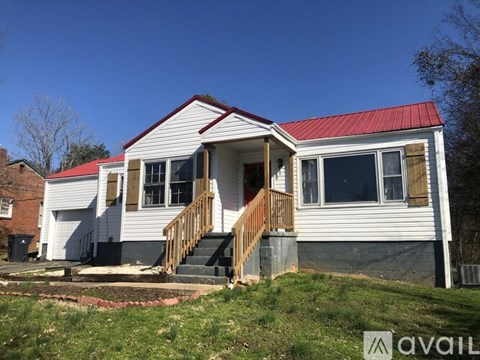 A house with a red roof and a porch.
