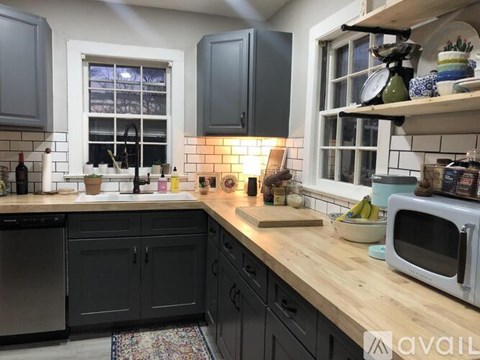A kitchen with wooden countertops and a white microwave.