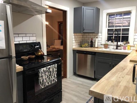 A kitchen with a black stove top oven and a wooden counter top.