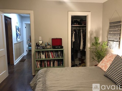 A bedroom with a bed, a bookshelf, and a closet.
