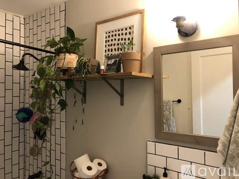 A bathroom with a shelf above the toilet paper.