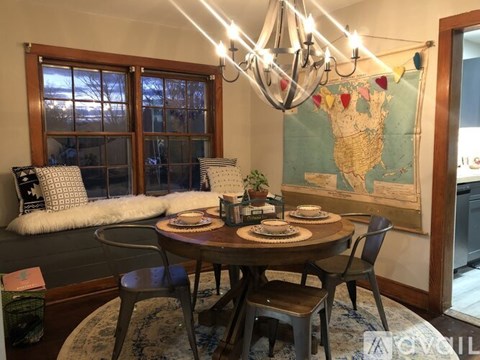 A dining room with a table set for four and a map on the wall.