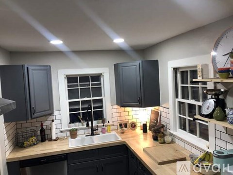 A kitchen with black cabinets and a white sink.
