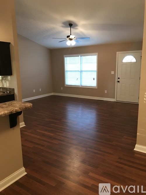 A room with wooden floors and a ceiling fan.