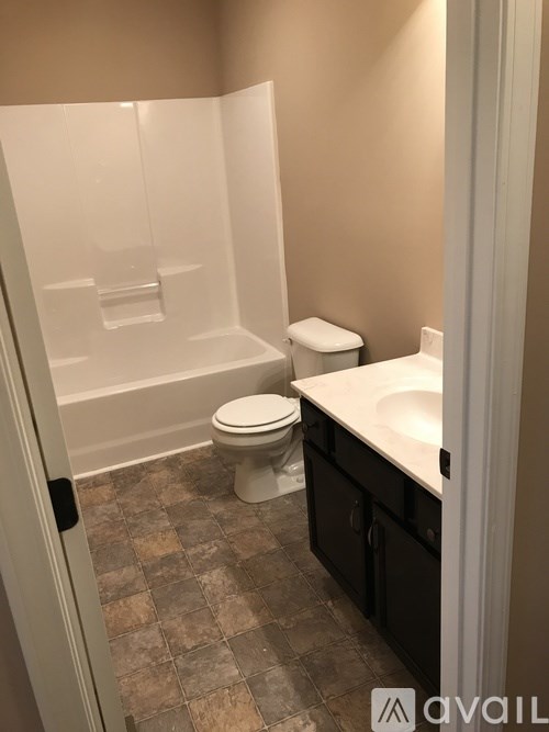 A bathroom with a toilet, sink, and tiled floor.