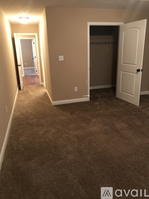 A room with a carpeted floor and a door on the right.