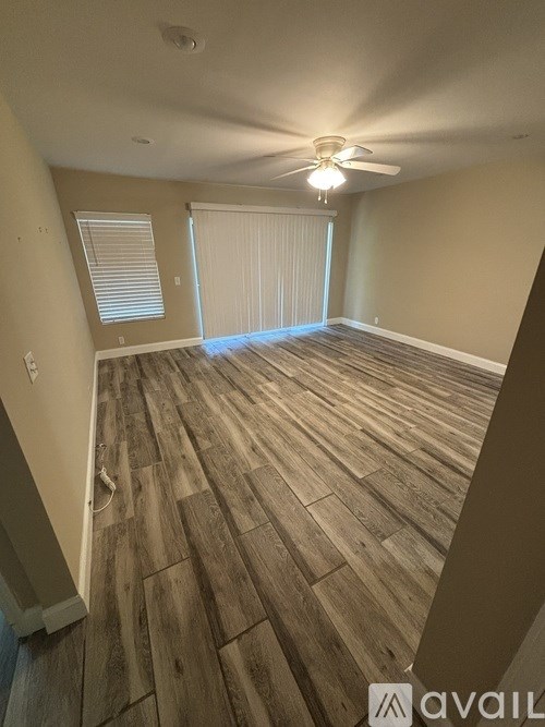 A room with wooden flooring and a ceiling fan.