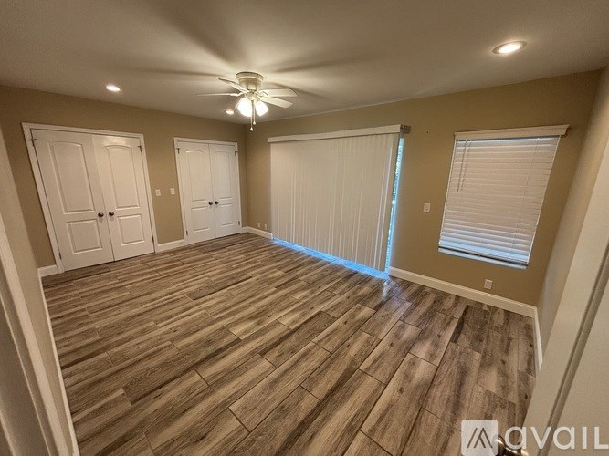 A room with wooden flooring and a ceiling fan.