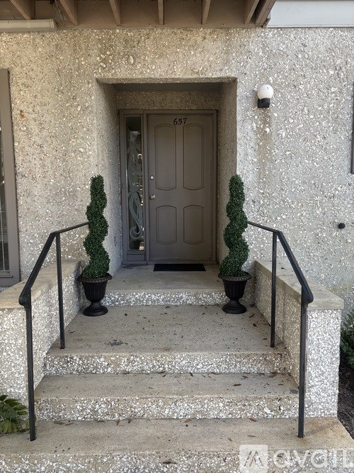 A set of stairs leading to a door with a number 657 on it.