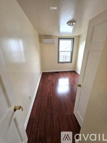 A hallway with wood floors and white walls.