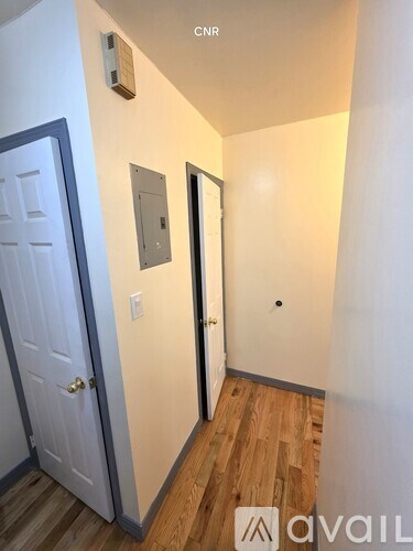 A hallway with a door on the left and a door on the right.