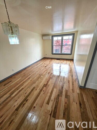 A room with wooden flooring and a window.