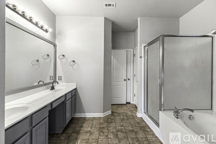 A bathroom with a sink, mirror, and shower.