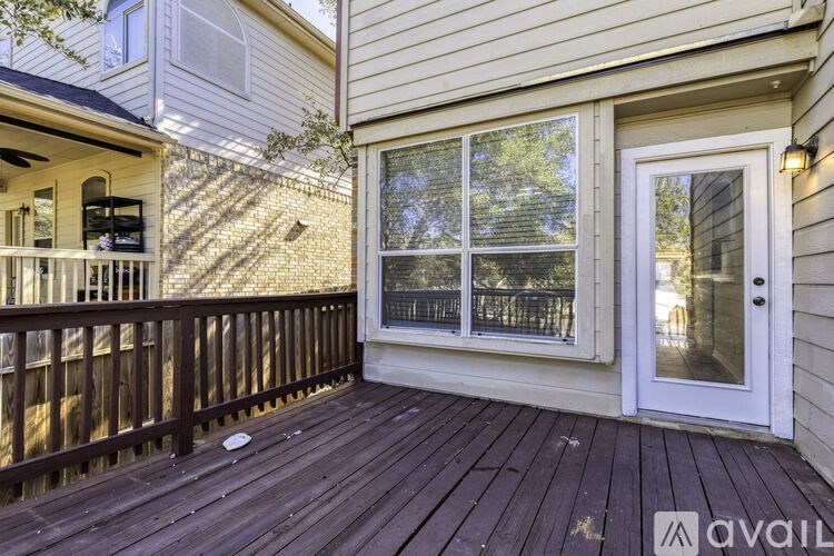 A wooden deck with a glass door and a window.