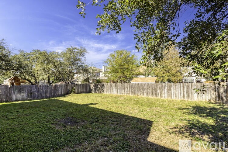 A backyard with a wooden fence and trees.