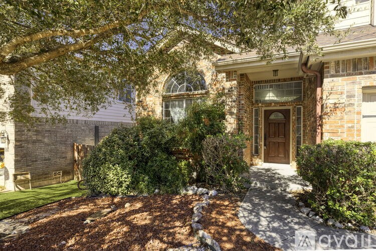 A house with a brown door and a tree in front.