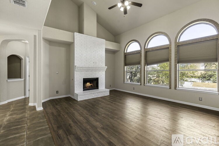 A spacious living room with a fireplace and large windows.