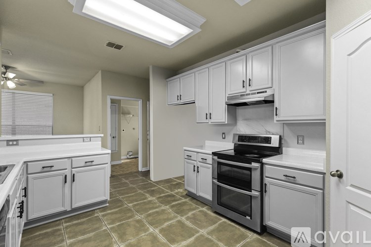 A kitchen with white cabinets and a stainless steel dishwasher.
