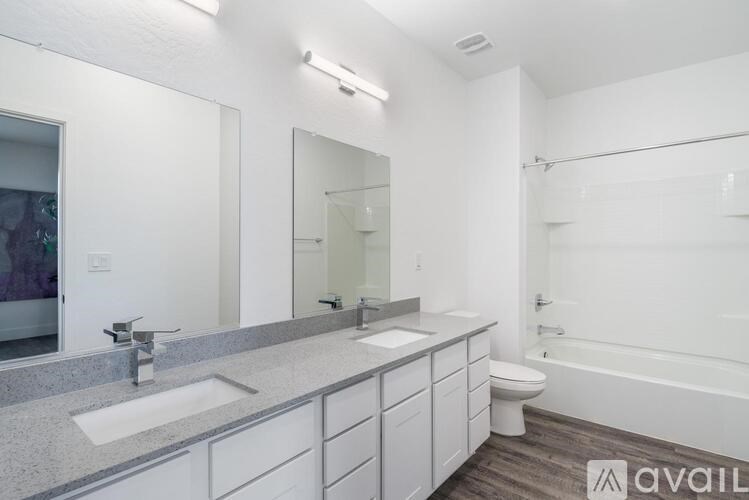 A bathroom with a white toilet, sink, and bathtub.
